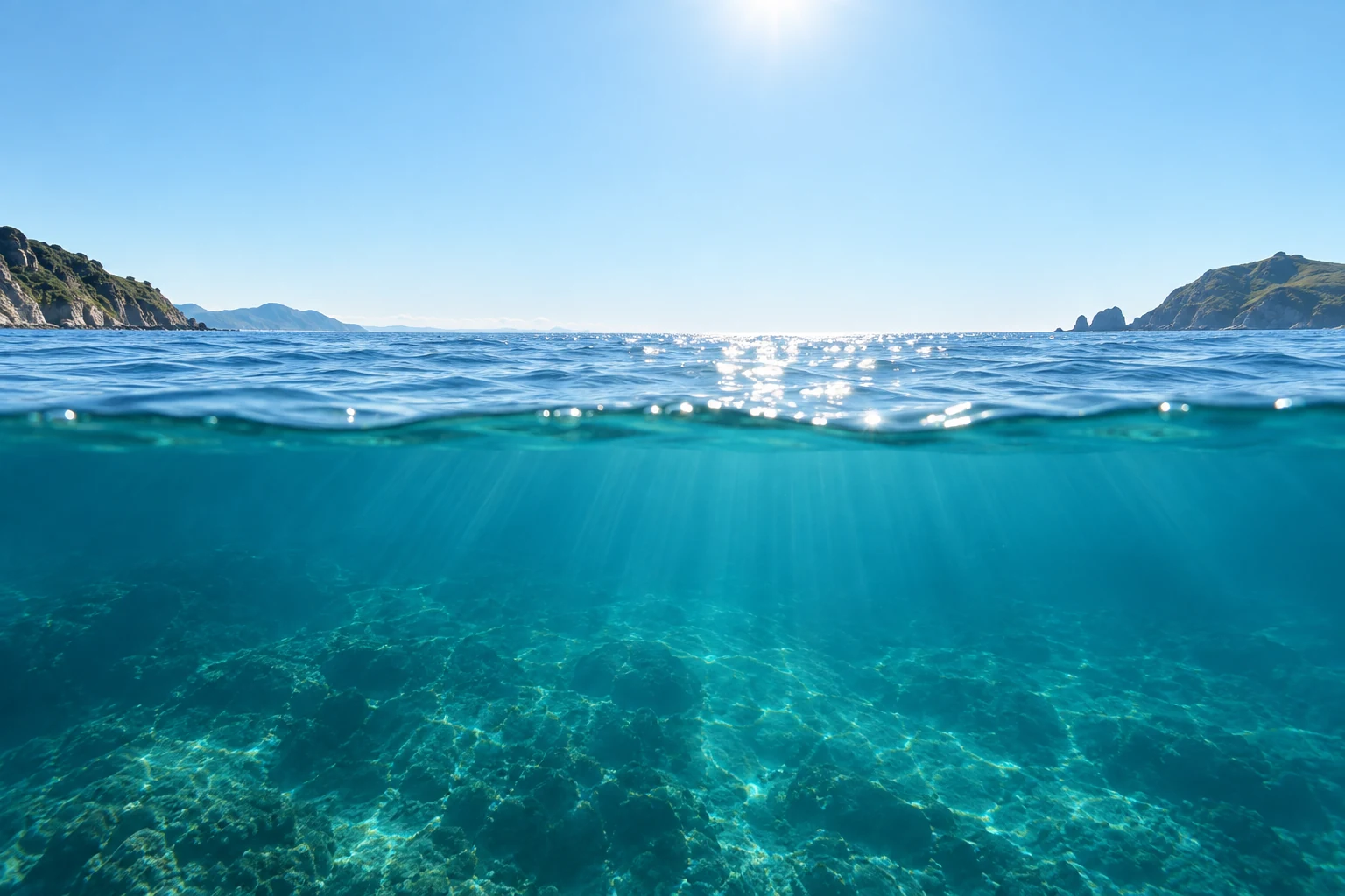 Sunlight over a clear New Zealand ocean, seen above and below the waterline